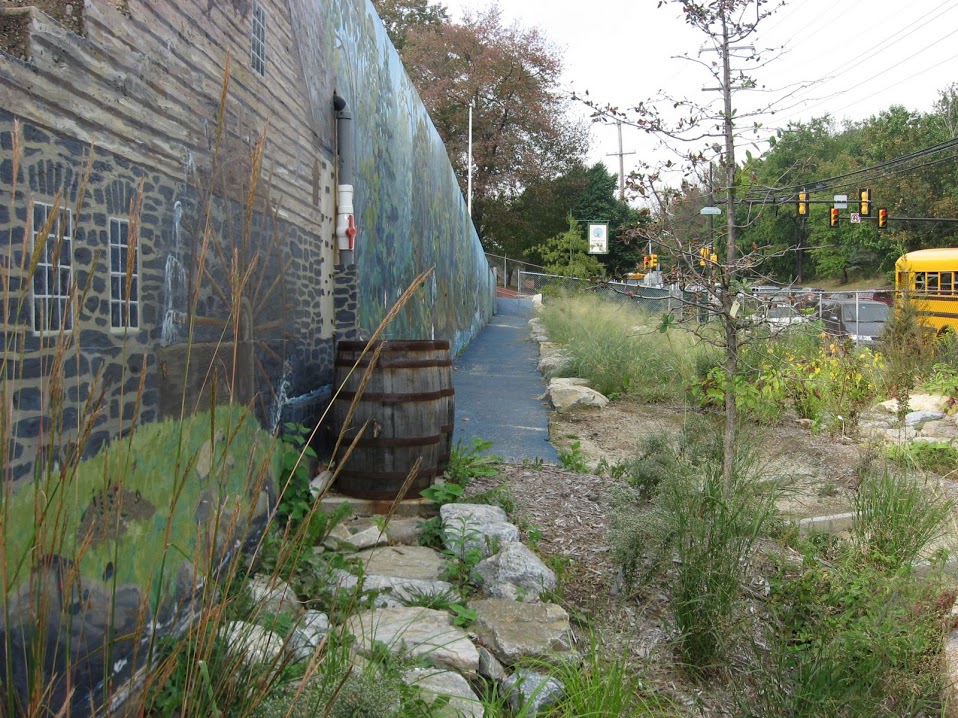 A wooden rain barrel under a downspout beside a house, in a U.S. Environmental Protection Agency photo from October 27, 2014. This barrel is not in Fulshear, and the ordinance does not require rain barrels.